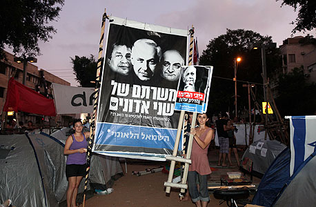 מפגינים מניפים שלטים הערב בת"א מפגינים מניפים שלטים הערב בת"א