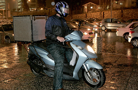 A delivery person on a motorcycle. Photo: Shaul Golan