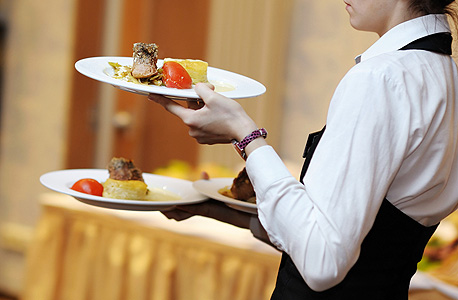 A waiter carrying food at a restaurant. Photo: Shutterstock