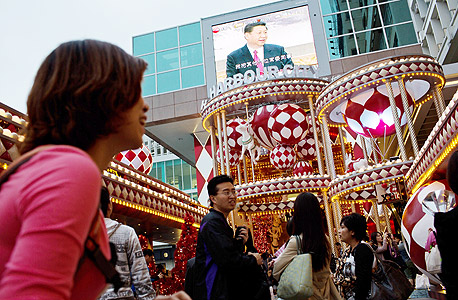 תושבים בהונג קונג מתבוננים במסיבת העיתונאים של נשיא סין החדש