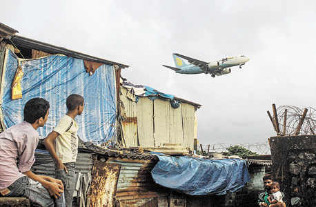 מטוס נוחת בנמל התעופה של מומבאי, ליד אנאוואדי. רק לשישה מאלפי התושבים יש 