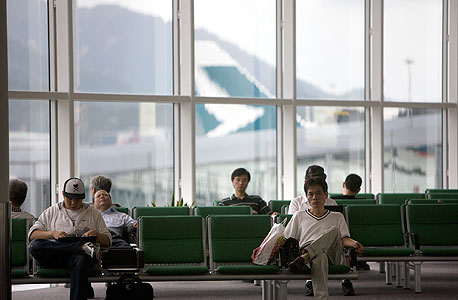 שדה התעופה הבינלאומי בהונג קונג. חפשו את המושבים שמאחורי העציצים
