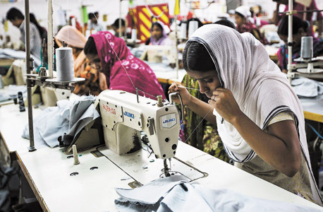 תופרת במפעל בדאקה, בנגלדש. ריבולי: "לא בטוח שבנגלדש תצליח להתקדם כפי שקרה לסין", צילום: בלומברג