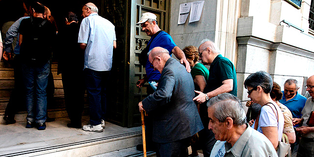 תור של אזרחי יוון ליד אחד מסניפי הבנקים באתונה, צילום: רויטרס
