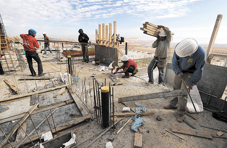 פועלים פלסטינים בונים בהתנחלויות, צילום: בלומברג