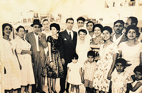 1960. רמי לוי, בן חמש (שני מימין בחולצה פרחונית), עם אמו (בשמלה לבנה מאחוריו) ואביו (מאחוריה), בחתונה משפחתית בירושלים 1960. רמי לוי, בן חמש (שני מימין בחולצה פרחונית), עם אמו (בשמלה לבנה מאחוריו) ואביו (מאחוריה), בחתונה משפחתית בירושלים