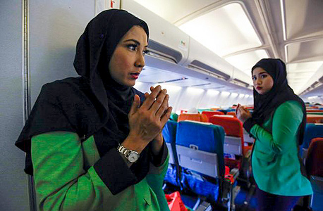 דיילת מוסלמית מתפללת חברת תעופה ריאני אייר Rayani Air מלזיה, צילום: איי פי