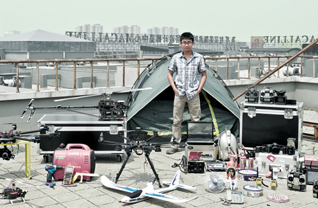 מתוך סדרת הצילומים של חואנג צ'ינגג'ון, המתעד סינים עם המוצרים שקנו ברשת: לי ניין (26) מבייג'ינג, יזם וחובב טיסנים, משלב בעבודתו ותחביביו גם טכנולוגיה וצילום - הכל בהתבסס על מוצרים ורכיבים שהוא קונה ברשת