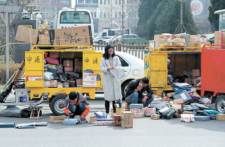 שליחים פורסים חבילות למרגלות בניין משרדים בבייג'ינג. מגיעים 