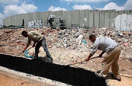 פועלים פלסטינים ליד גדר ההפרדה. מרוויחים יותר בישראל פועלים פלסטינים ליד גדר ההפרדה. מרוויחים יותר בישראל