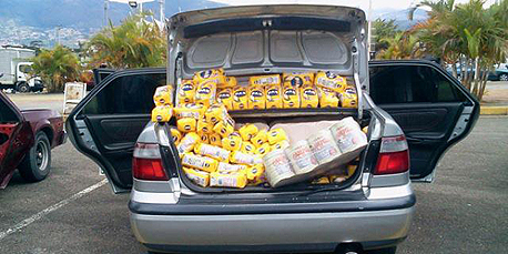 כך נראה השוק השחור בונצואלה. חבילות קמח שהוברחו למדינה נמכרות מתא המטען של הרכב , צילום: twitter