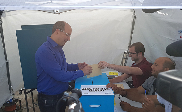 אבי ניסנקורן מצביע. עשרות תומכים חיכו לו אבי ניסנקורן מצביע. עשרות תומכים חיכו לו
