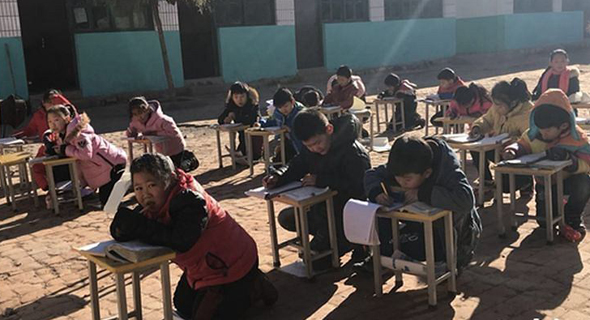 תלמידים בסין לומדים בחצר כדי להתחמם בשמש תלמידים בסין לומדים בחצר כדי להתחמם בשמש