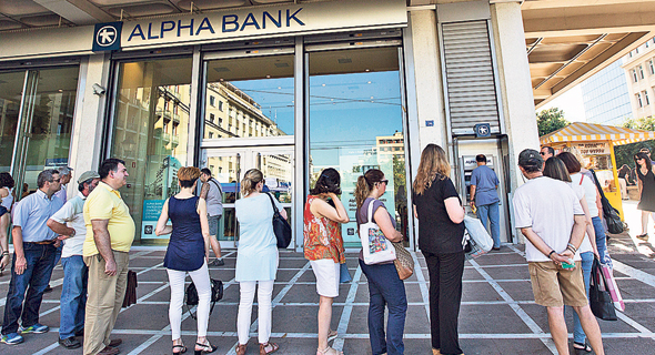 תור לכספומט באתונה, סמל למשבר הכלכלי המתמשך, יולי 2015. המשק חזר לצמוח, אך האבטלה עדיין גבוהה 
