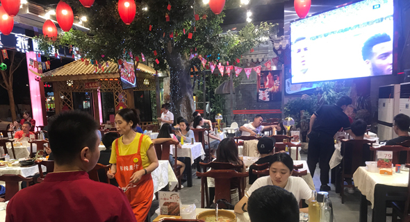 מסעדה בבייג'ינג. אוכלים סרטן נהרות מול המסך