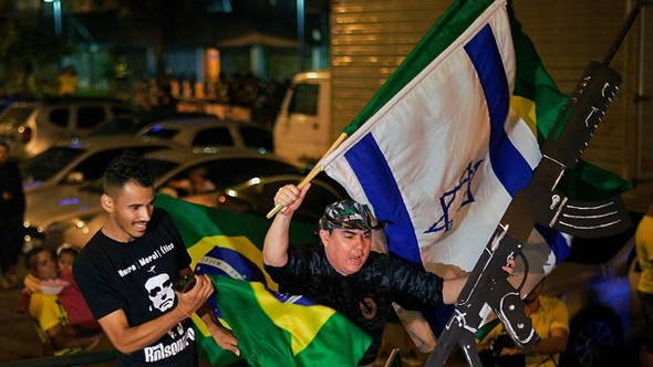 תומכי ז'איר בולסונרו חוגגים ברחובות  עם דגם רובה ודגל ישראל 