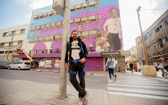 גווטירז על רקע ציור הקיר שלו. "ציירתי את פואד, השרת בבית הספר הסמוך שהכרתי השבוע. רוב האנשים סביבו בקושי מברכים אותו לשלום" גווטירז על רקע ציור הקיר שלו. "ציירתי את פואד, השרת בבית הספר הסמוך שהכרתי השבוע. רוב האנשים סביבו בקושי מברכים אותו לשלום"