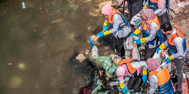 מתנדבים מושים פסולת מנהר הנילוס בקהיר, לפני חודש. “הסביבה היא הראשונה להיפגע", צילום: איי אף פי