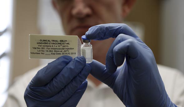 A lab technicial holds up a vial of a Covid-19 vaccine used in a clinical trial. Photo: Getty Images