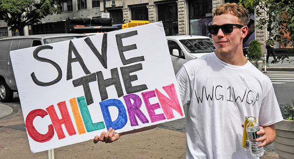 מפגין נושא שלט Save The Children מפגין נושא שלט Save The Children