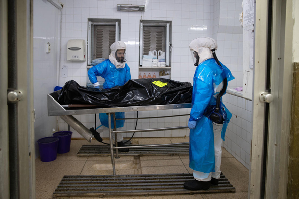 אנשי חברה קדישא מטפלים בנפטר מקורונה, צילום: אלכס קולומויסקי