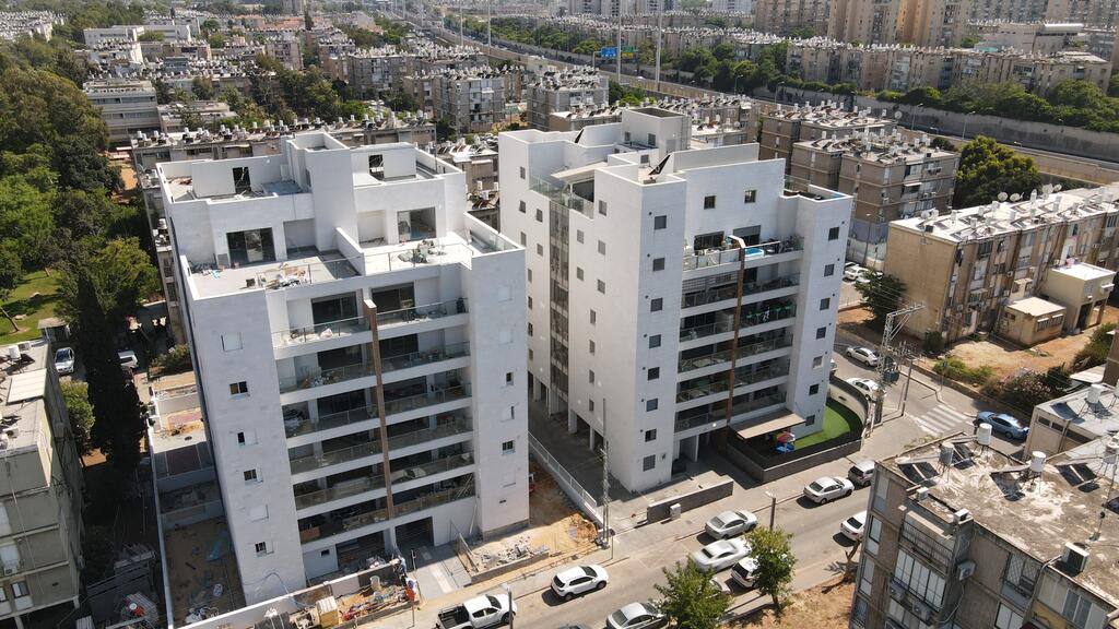 הבניין הימיני הוגש ב-2016 ללא רישוי זמין, ואילו השמאלי הוגש ב-2017 עם רישוי זמין, הפרש הזמנים לקבלת היתר בניה - 8 חודשים (יח"צ) בנייה בחולון התחדשות עירונית אלמגורים השקעות ונדל"ן