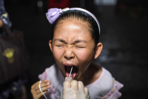 בדיקה לגילוי קורונה בסין, צילום: איי אף פי