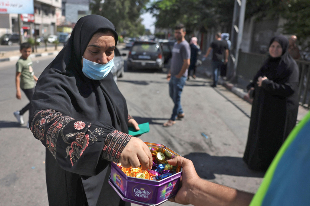 אשה מקבלת ממתקים שמחולקים ברחוב ב רצועת עזה