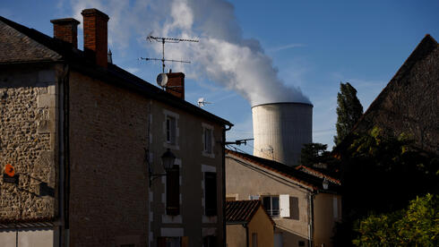 ארובת קירור בכור בסיבו שבצרפת על רקע בתי התושבים, צילום: רויטרס