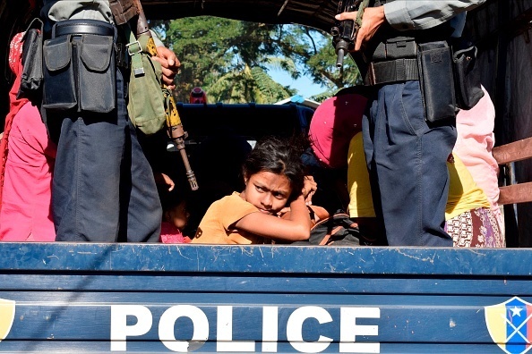 שוטר במיאנמר מלווה ילדה בת רוהינגה למחנה שלה לאחר שניסתה לברוח מהמדינה, גטי