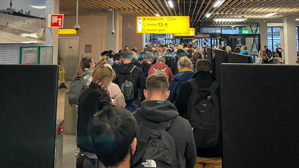 קורונה תור ב נמל התעופה ב אמסטרדם בעקבות איסור כניסת אזרחים ממדינות ב אפריקה בעקבות מציאת הזן החדש של הקורונה אומיקרון
