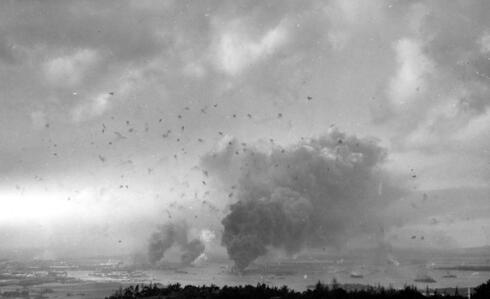 פרל הארבור תוך כדי גל המתקפה השני. שימו לב לפטריות השחורות הקטנות באוויר, זוהי אש נ"מ, צילום: USN