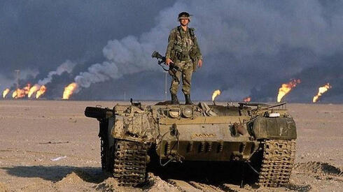 חייל אמריקאי על טנק מושמד, על רקע שדות נפט בוערים בעיראק, צילום: AP